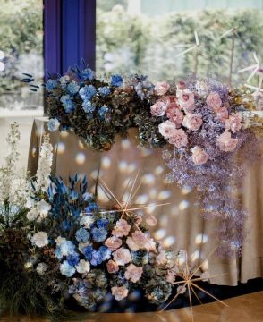 Celestial Bloom sweetheart table décor with pastel roses, blue blooms, dried flowers, and golden accents in Edmonton