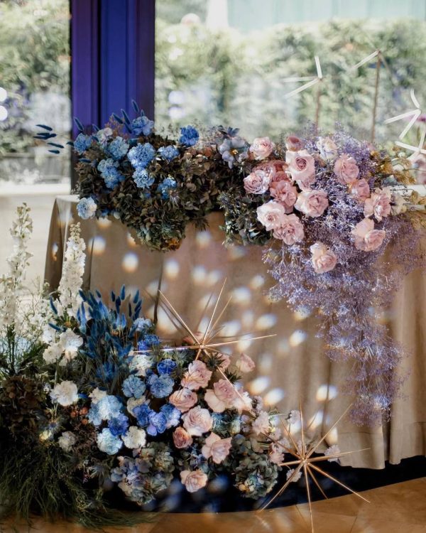 Celestial Bloom sweetheart table décor with pastel roses, blue blooms, dried flowers, and golden accents in Edmonton