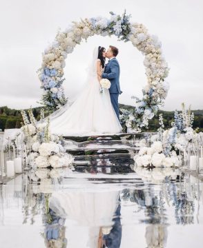 Eternal Sky round wedding arch with white roses, blue hydrangeas, and greenery in Edmonton