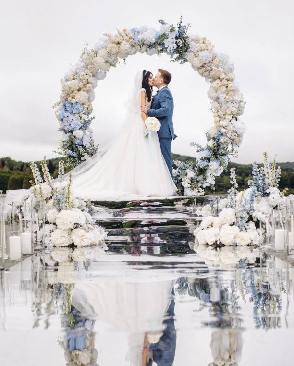 Eternal Sky round wedding arch with white roses, blue hydrangeas, and greenery in Edmonton