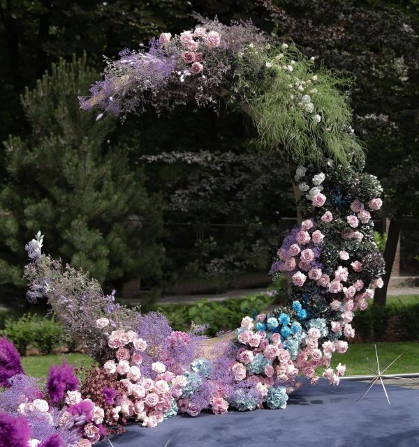 Moonlight Symphony crescent wedding arch with pastel roses, purple flowers, and celestial décor in Edmonton